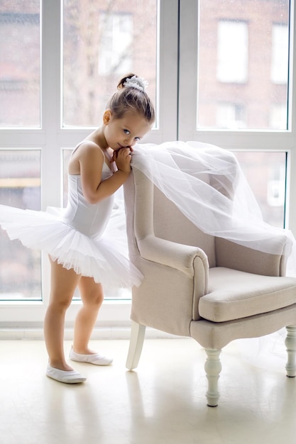 Foto piccola ballerina di due anni in studio con un vestito bianco tutu