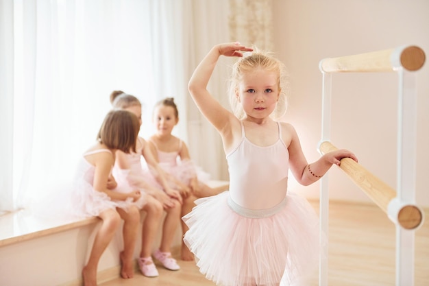 Little ballerinas in pink uniforms preparing for performance