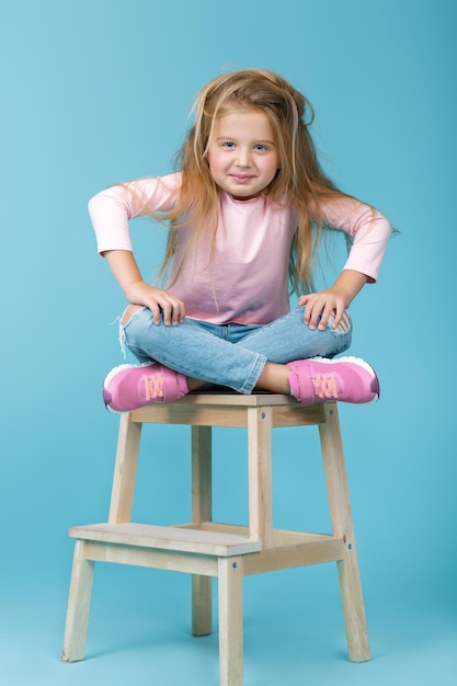 Photo little beautiful angry girl in pink sweater and jeans