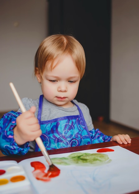 Piccola bellissima bambina, dipinge con gli acquerelli nell'album