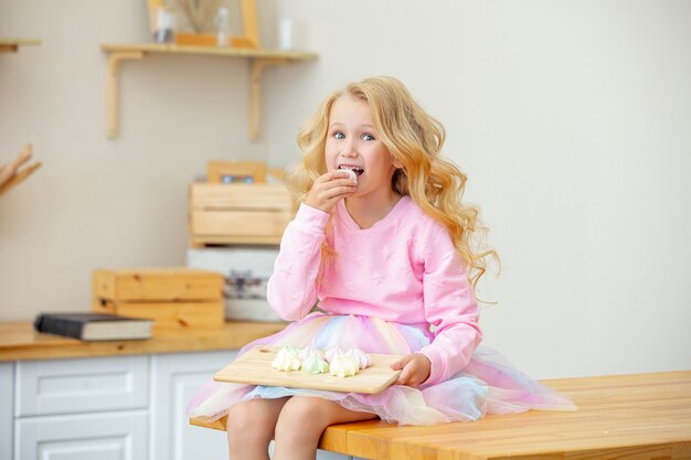 幸せで面白い自宅のキッチンで小さな美しい子供の女の子