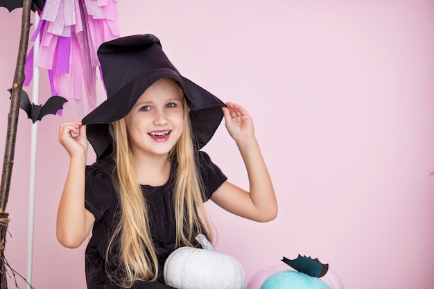 ファッショナブルなハロウィーンの装飾の魔女のカーニバルの衣装で小さな美しいかわいい子供の女の子