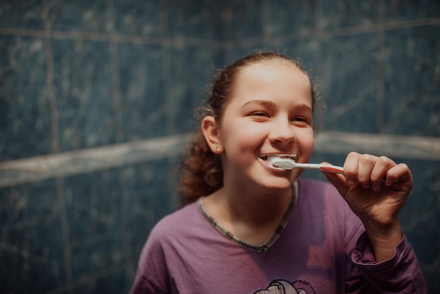 Маленькая красивая девочка чистит зубы здоровой концепцией