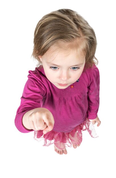 Photo little beautiful girl points with index finger forward, top view, isolated on white background