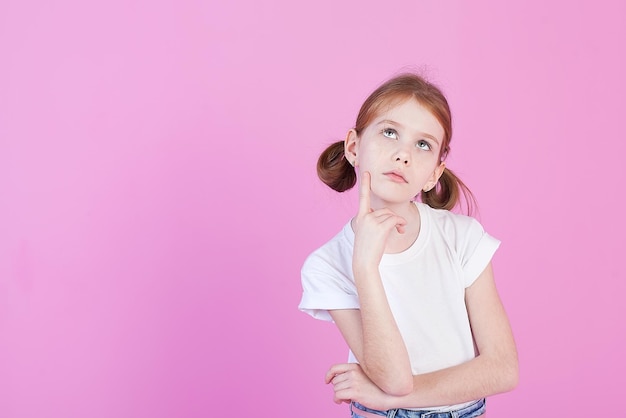 A little beautiful smiling girl in the studio closeup portrait isolated pink background childhood lifestyle facial expressions grimaceinterests hobbies free time free time