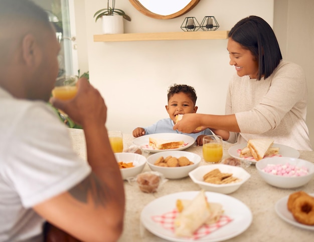 家の裏庭でのんびりと昼食をとっている幸せな若い家族のショット