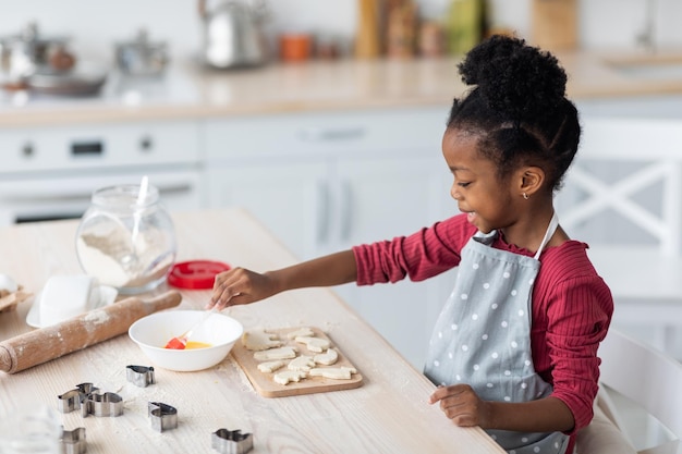 Premium Photo | Little black girl baking cookies alone at home