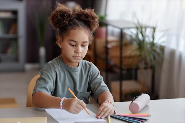 사진 색연필을 사용하여 집에서 그림을 그리는 어린 흑인 소녀