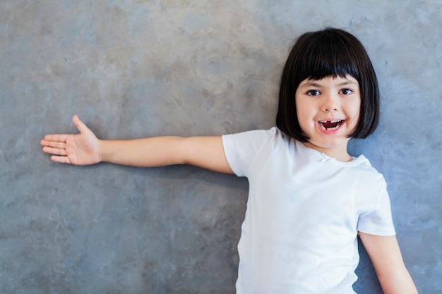 Photo little blackhair girl by wall