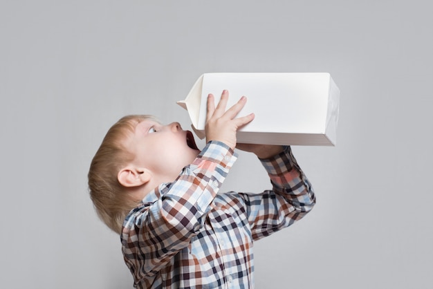 Little blond boy drinking from a large white container