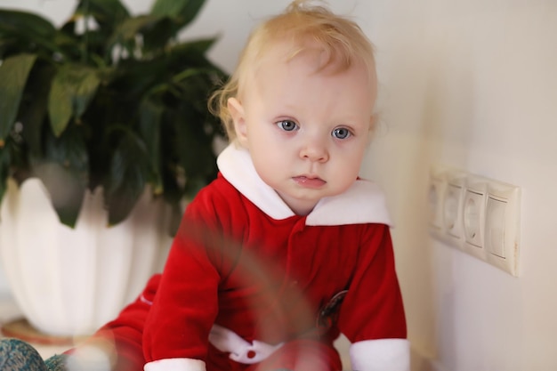 Little blond child in the kitchen sits on a table