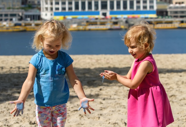 Little blond girls having paint on their hands