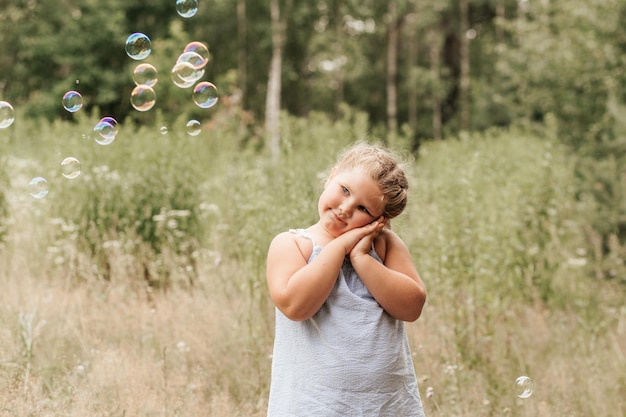 Little blond hair girl play with soap bubbles in park family activity during summer Feeling happiness joyful cheerful and enjoying Playing in garden during sunbeam