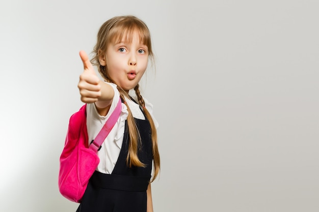 little blond school girl with backpack bag portrait isolated on white background