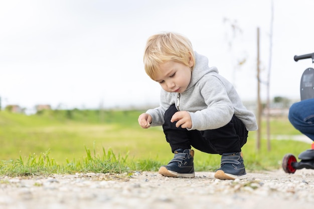 A little blonde boy on walk by the field