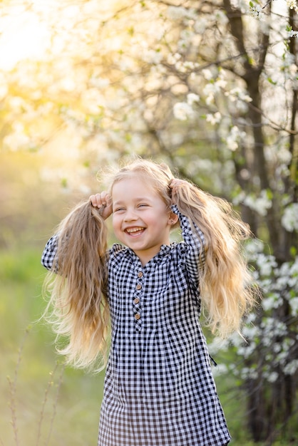 Little blonde girl having fun in the spring park.