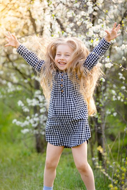 Little blonde girl having fun in the spring park.