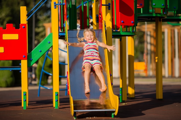 little blonde girl playing in a children's town