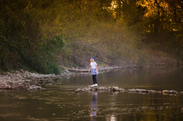 Little blonde girl on the riverside