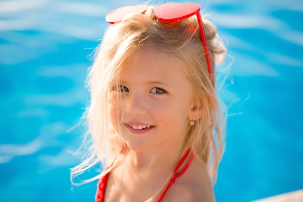 little blonde girl in swimming pool in summer