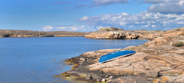 Little blue boat returned to the swedish granite coast by the baltic sea in island of Smogen