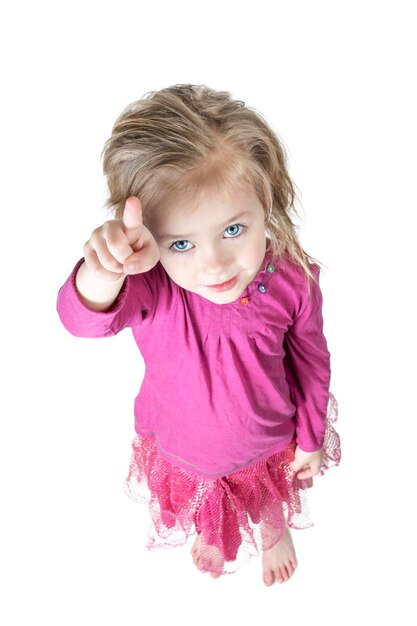 Little blue-eyed girl shows with index finger up, top view, isolated on white background