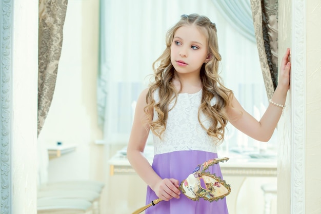 Little blueeyed model posing with masquerade mask