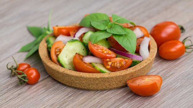 A little bowl of salad with tomatoes and cucumbers
