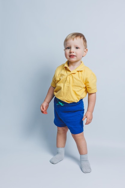 Little boy 3 years old in a yellow Tshirt and blue shorts a boy in a sports uniform