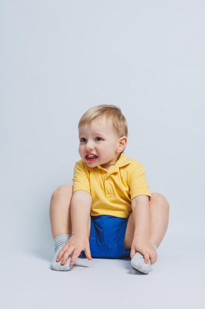 黄色のTシャツと青いショートパンツを着た3歳の男の子スポーツユニフォームを着た男の子