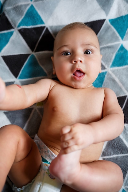 Little boy age 8 months and is smiling. He wears a diaper. Health and development of children