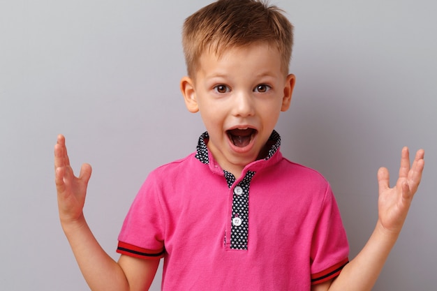 little boy amazed and shocked wearing pink t-shirt