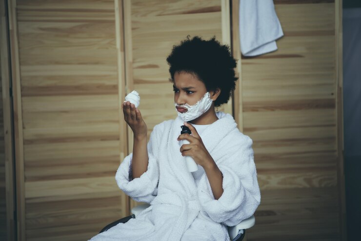 Photo little boy applied shaving foam and looks.