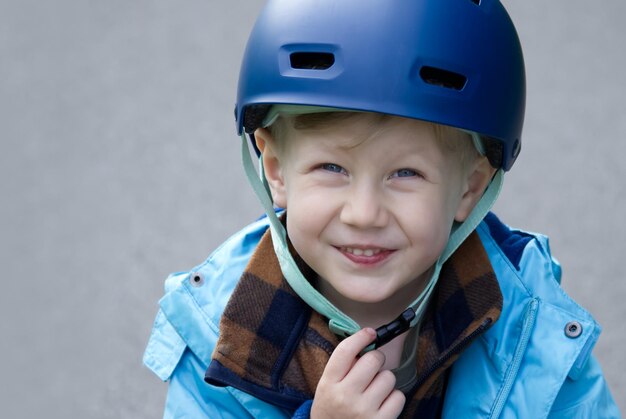 自転車のヘルメットをかぶった小さな男の子がカメラを見て微笑んでいる