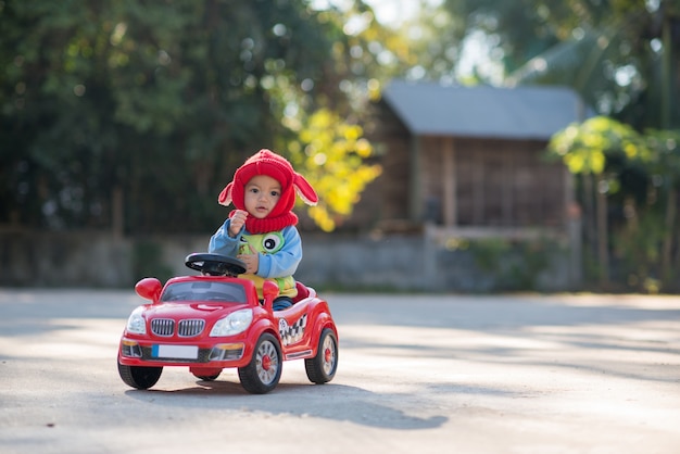 大きな車のおもちゃの小さな男の子カメラを見て笑って