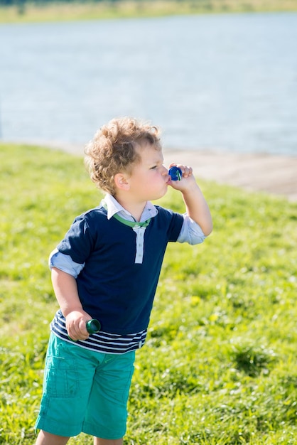 晴れた夏の日に公園で泡を吹く小さな男の子