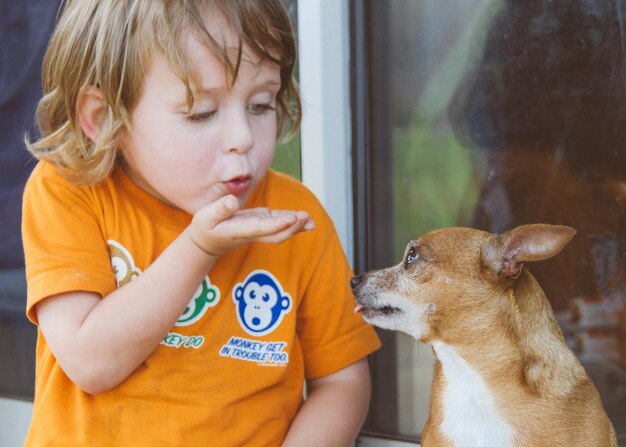 Foto un ragazzino che fa un bacio al cane.