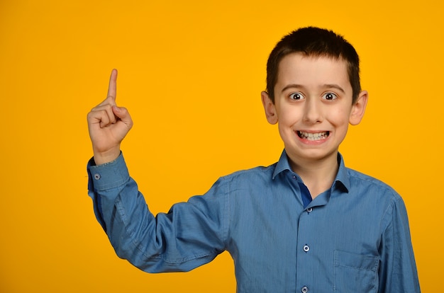 Foto il ragazzino in camicia blu fa la faccia buffa