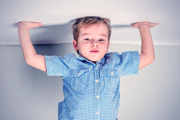 Little boy in a blue shirt stands on his hands