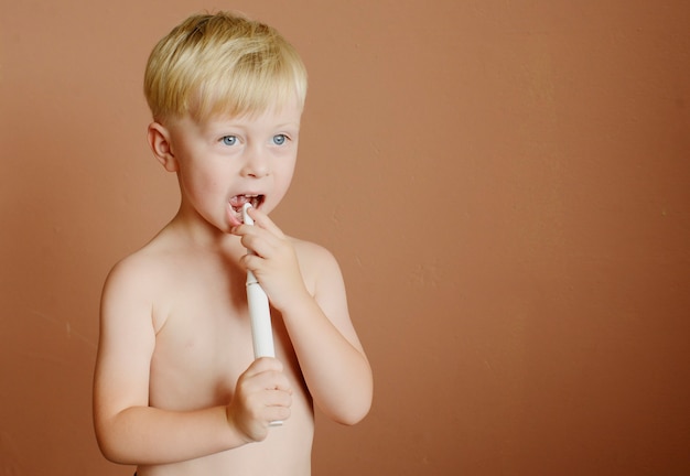 Photo little boy brushing his teeth