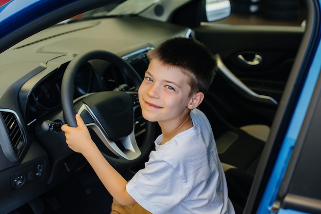 little boy in a car at the dealership showroom