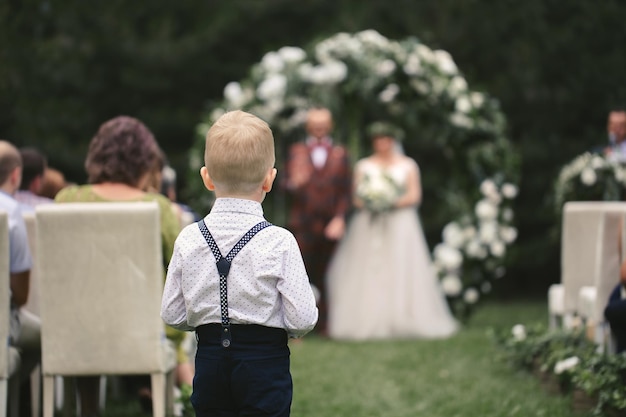 小さな男の子が新郎新婦のために結婚指輪を運びます