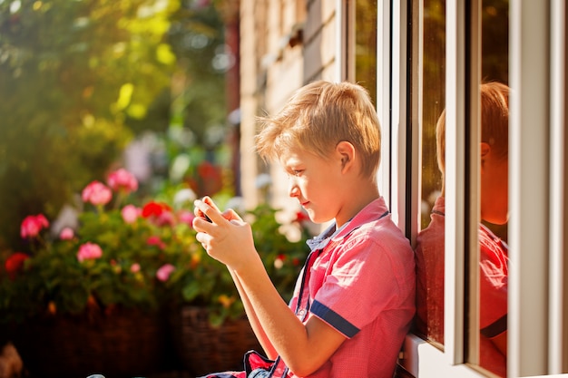 Little boy child kid playing games on smartphone mobile phone ou