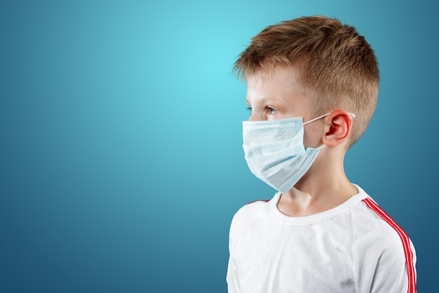 Little boy, a child in a medical mask on a blue