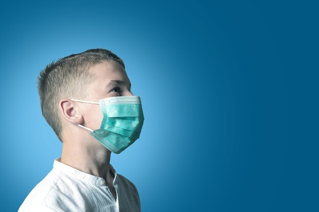 Little boy a child in a medical mask on a bright background