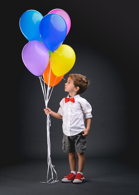 Little boy, child, playing with colorful balloons (bladders)