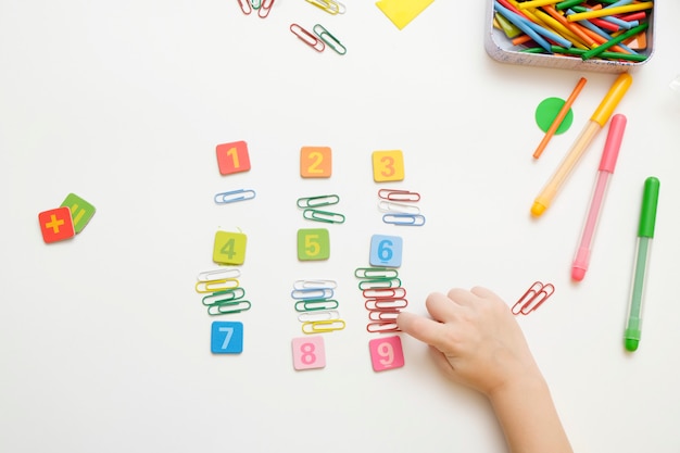 Photo little boy child preparing for elementary school doing simple mathematics exercises.