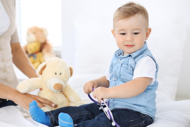 Little boy child with his mother at health exam at doctor\'s\
office