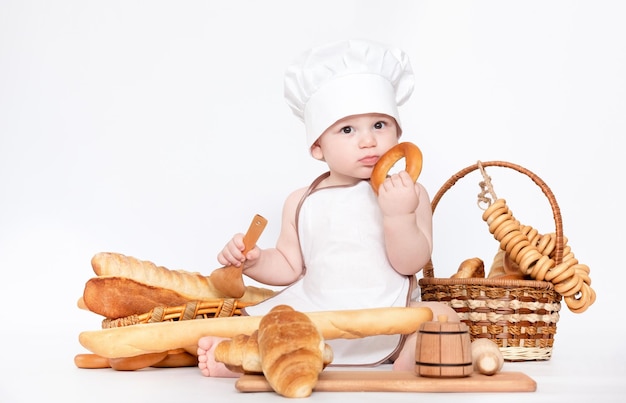 Little boy in a cook cap and with bread funny little chef