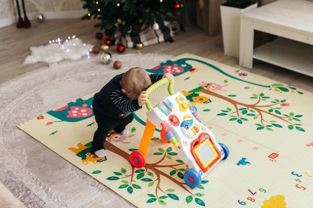 Photo little boy cute child playful toddler making first steps learning to walk playing